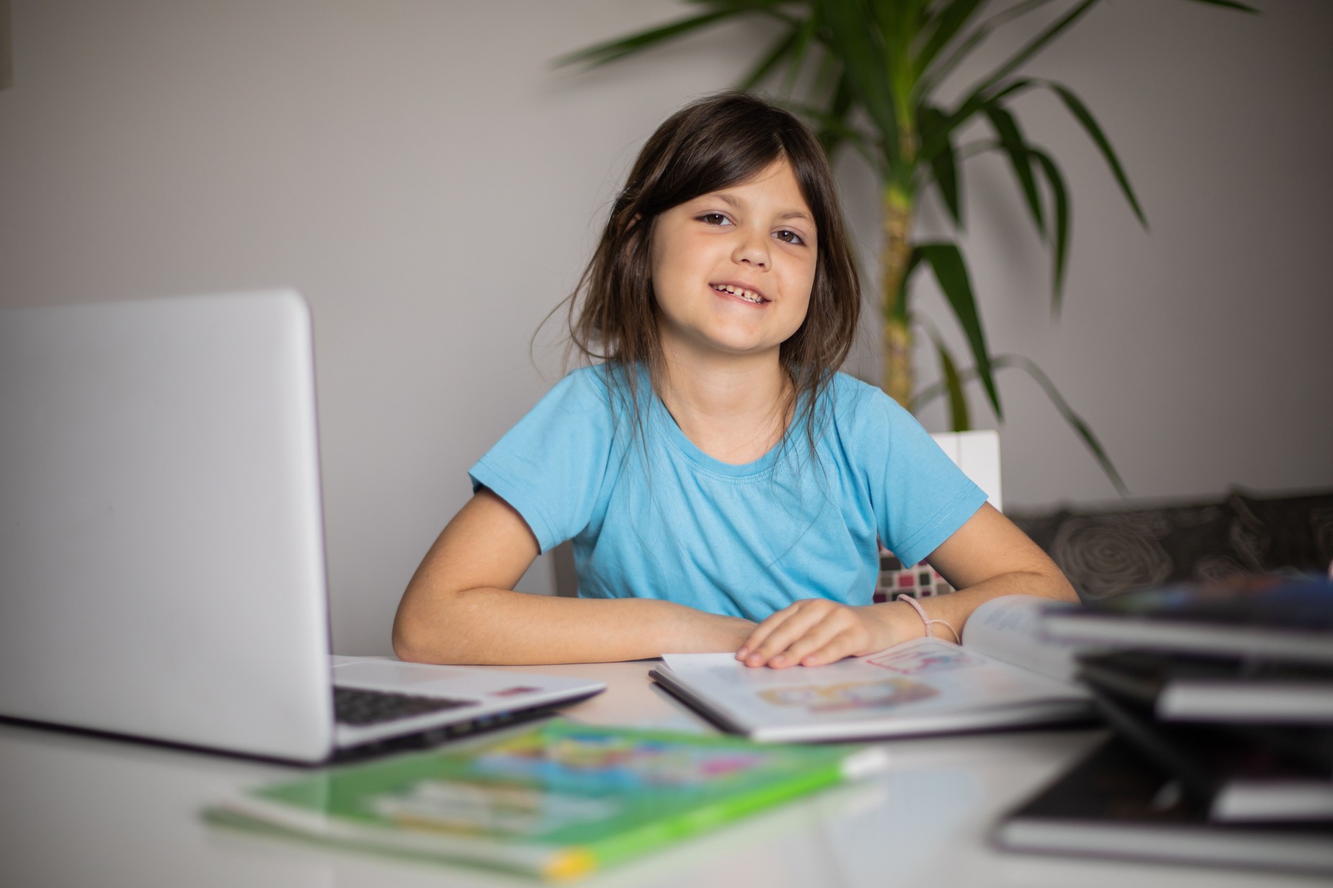 The portrait of little girl who is studying at home and doing her homework.